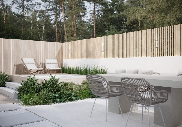 Modern backyard patio or terrace in Randwick with two lounge chairs, a seating area with a table and chairs, lush green plants, and wooden fence.